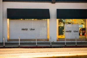 Exterior of a Hertz car rental outlet in Los Angeles, California, with branded signage and parked vehicles