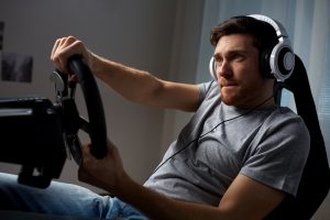 Anxious man practicing to drive using car simulation game