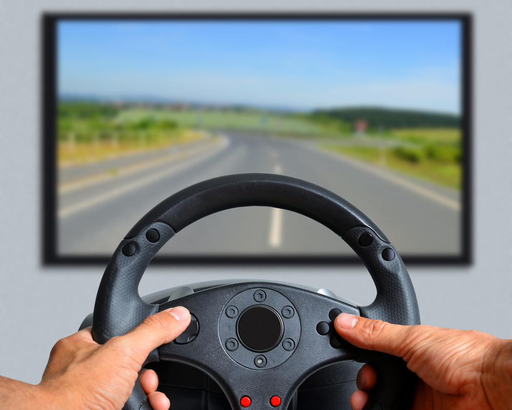 Man using steering wheel controller for car simulation game