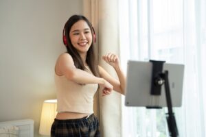 Woman dancing and filming short-form content with a tablet on a tripod