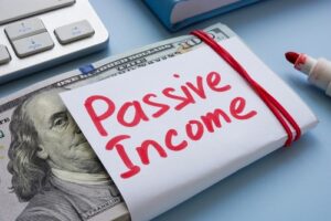 Stack of hundred-dollar bills wrapped in a note labeled “Passive Income”