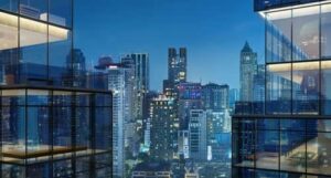 Luxury high-rise buildings in a dense urban skyline at night, representing upscale city living.